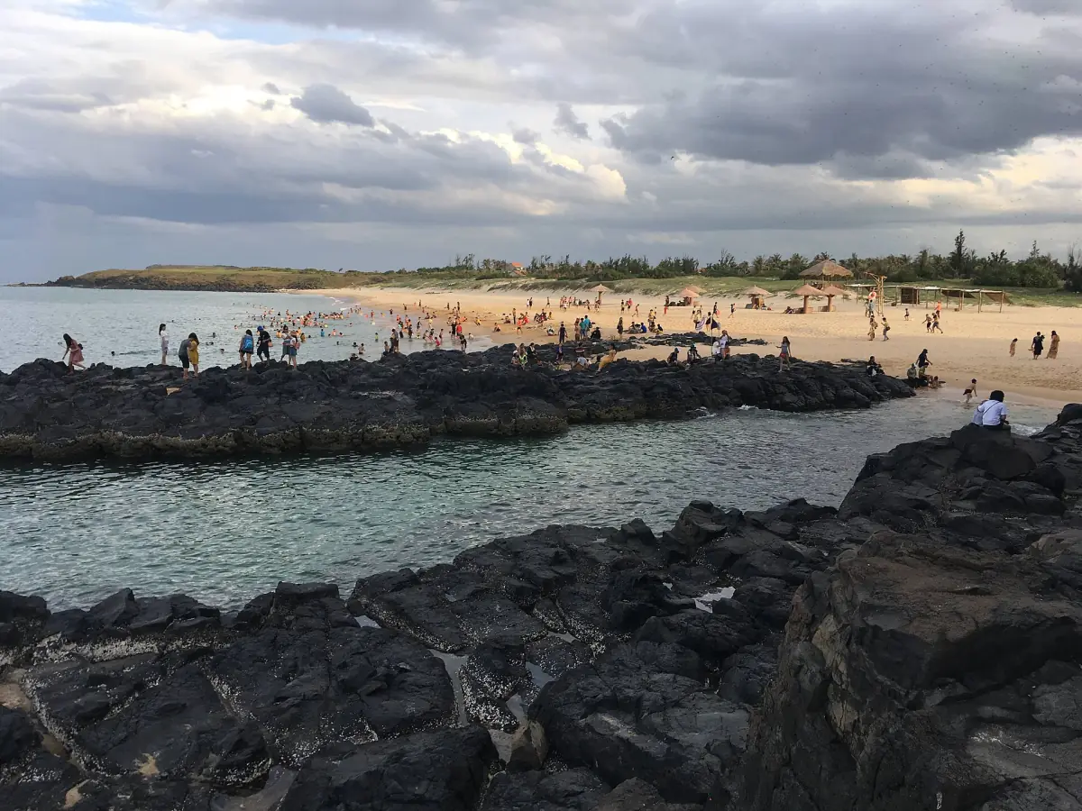 Dark rocks and swimmers at Bai Xep