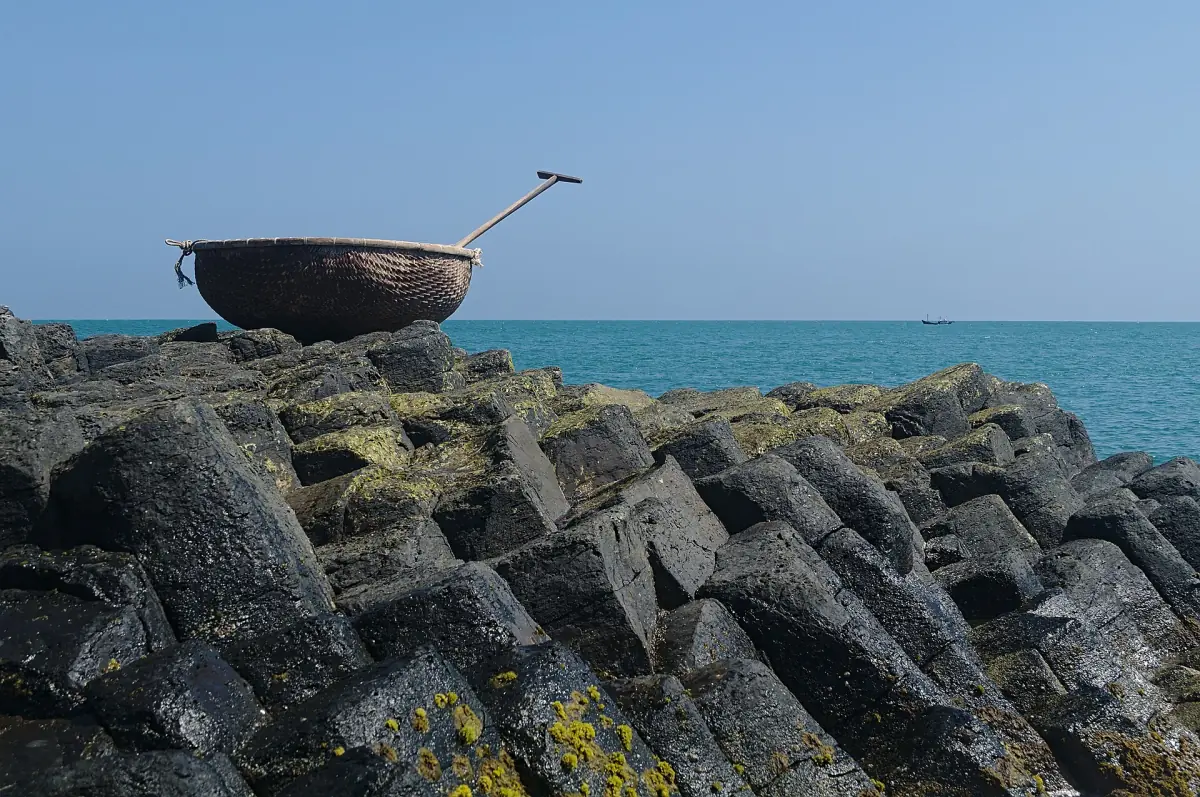 A round basket boat resting on the basalt columns